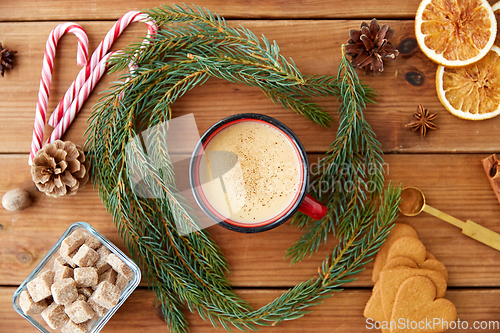 Image of cup of eggnog, fir branches, gingerbread and sugar