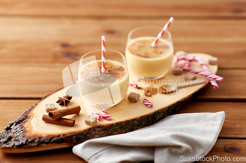 Image of glasses of eggnog, ingredients and spices on wood