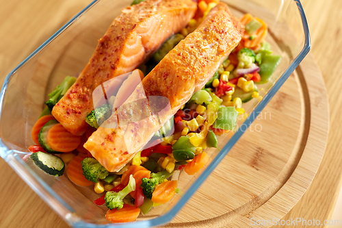 Image of salmon fish in baking dish on kitchen table