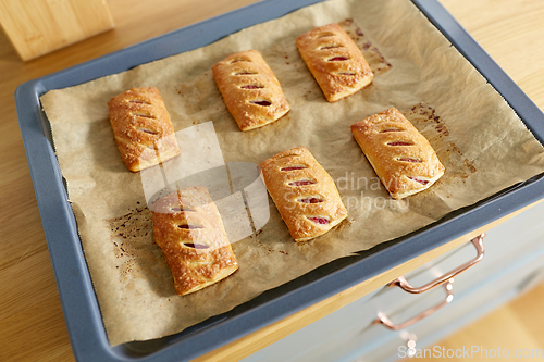 Image of baking tray with jam pies at home kitchen