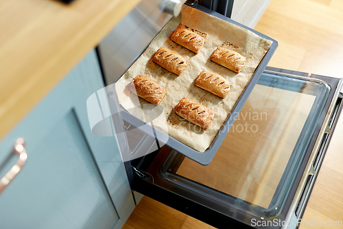 Image of baking tray with jam pies in oven at home kitchen