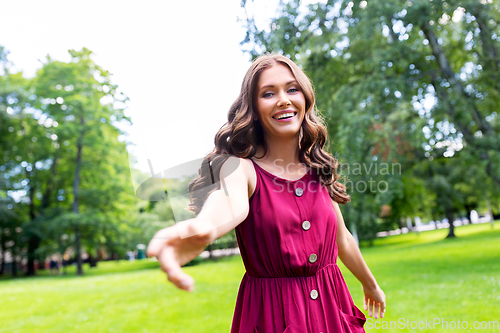 Image of portrait of happy smiling woman at summer park