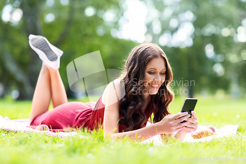 Image of happy woman with smartphone at park