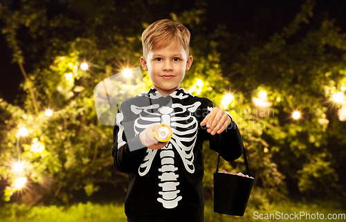 Image of boy with candies and flashlight on halloween