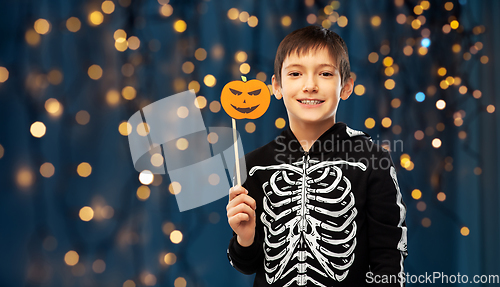 Image of boy in halloween costume of skeleton with pumpkin