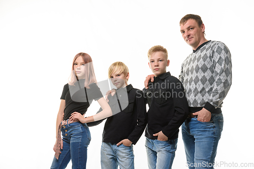 Image of Dad, two sons and a daughter in casual clothes in dark colors, white background