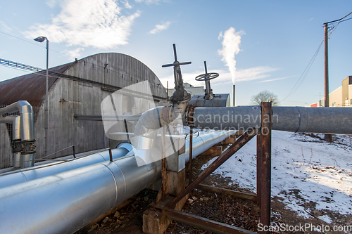 Image of outdoor pipeline and old hangar in winter