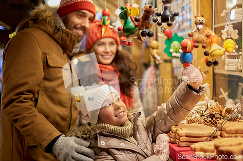 Image of happy family buying souvenirs at christmas market