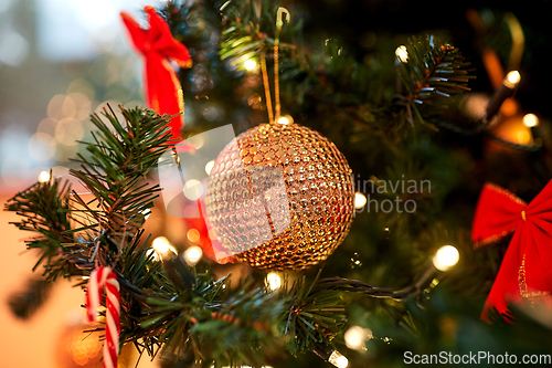 Image of golden christmas ball decoration on fir tree