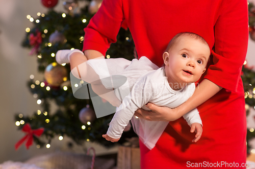 Image of mother with happy baby daughter at christmas tree