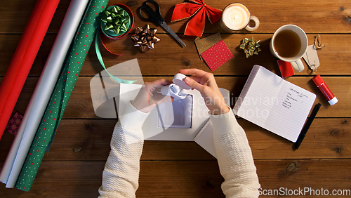 Image of hands packing earphones for christmas gift