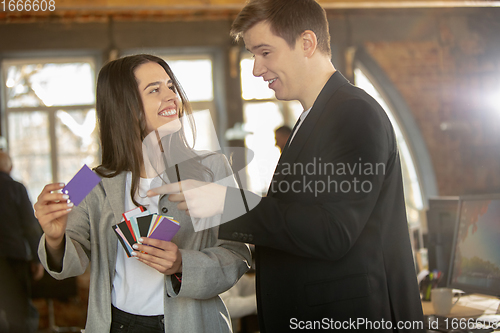 Image of Young caucasian colleagues working together in a office using modern devices and gadgets