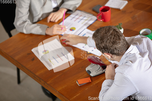 Image of Front view colleagues working together in a office using modern devices and gadgets during creative meeting