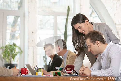 Image of Side view colleagues working together in a office using modern devices and gadgets during creative meeting