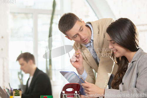 Image of Side view colleagues working together in a office using modern devices and gadgets during creative meeting