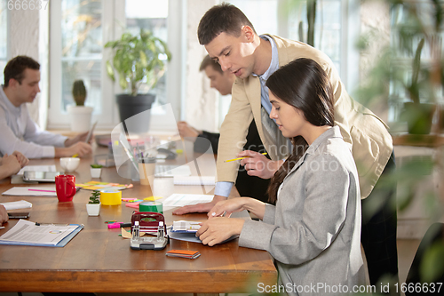 Image of Side view colleagues working together in a office using modern devices and gadgets during creative meeting