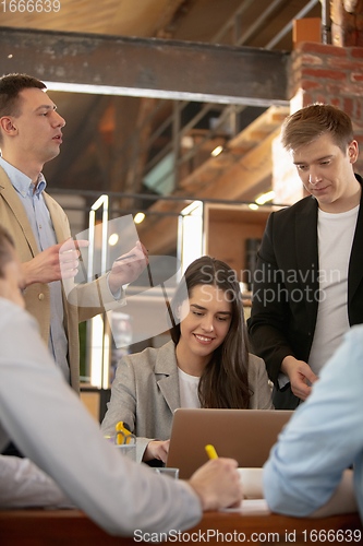 Image of Front view colleagues working together in a office using modern devices and gadgets during creative meeting