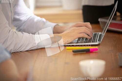 Image of Hands of colleagues working together in a office using modern devices and gadgets during creative meeting. Close up.