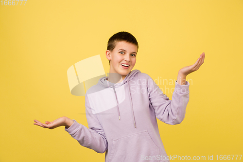 Image of Caucasian girl\'s portrait isolated on yellow studio background with copyspace