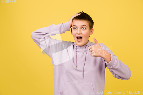 Image of Caucasian girl\'s portrait isolated on yellow studio background with copyspace
