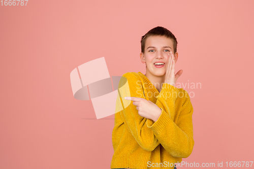 Image of Caucasian girl\'s portrait isolated on coral pink studio background with copyspace