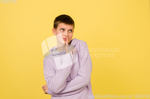 Image of Caucasian girl\'s portrait isolated on yellow studio background with copyspace