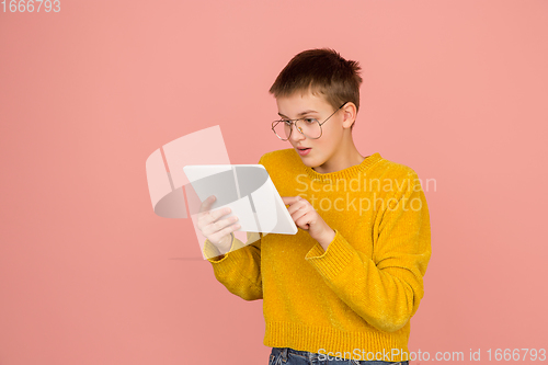 Image of Caucasian girl\'s portrait isolated on coral pink studio background with copyspace