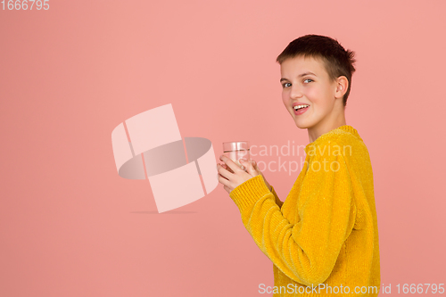 Image of Caucasian girl\'s portrait isolated on coral pink studio background with copyspace