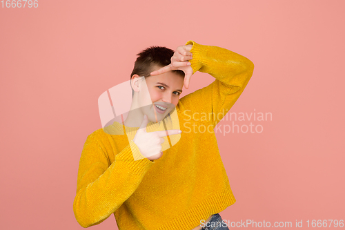 Image of Caucasian girl\'s portrait isolated on coral pink studio background with copyspace