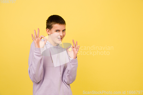 Image of Caucasian girl\'s portrait isolated on yellow studio background with copyspace