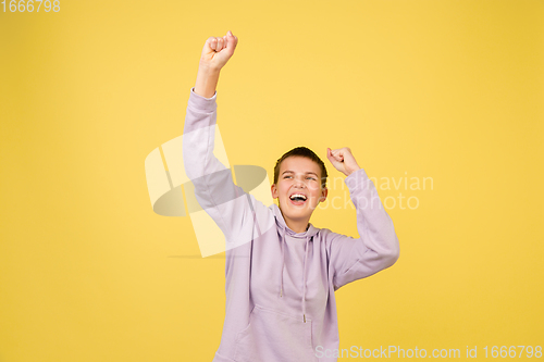 Image of Caucasian girl\'s portrait isolated on yellow studio background with copyspace