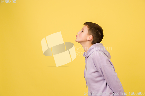 Image of Caucasian girl\'s portrait isolated on yellow studio background with copyspace