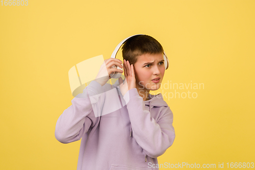 Image of Caucasian girl\'s portrait isolated on yellow studio background with copyspace