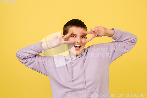 Image of Caucasian girl\'s portrait isolated on yellow studio background with copyspace