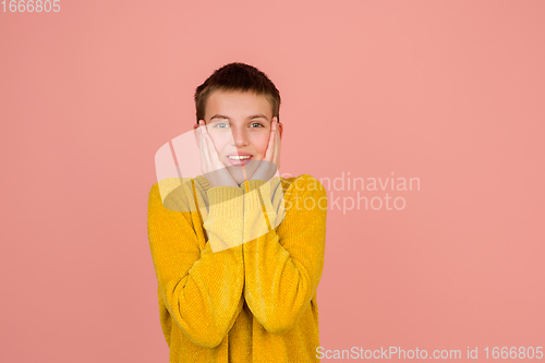 Image of Caucasian girl\'s portrait isolated on coral pink studio background with copyspace