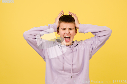 Image of Caucasian girl\'s portrait isolated on yellow studio background with copyspace