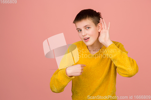 Image of Caucasian girl\'s portrait isolated on coral pink studio background with copyspace