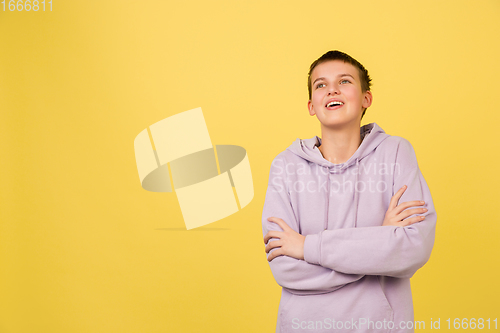 Image of Caucasian girl\'s portrait isolated on yellow studio background with copyspace