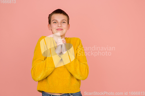 Image of Caucasian girl\'s portrait isolated on coral pink studio background with copyspace