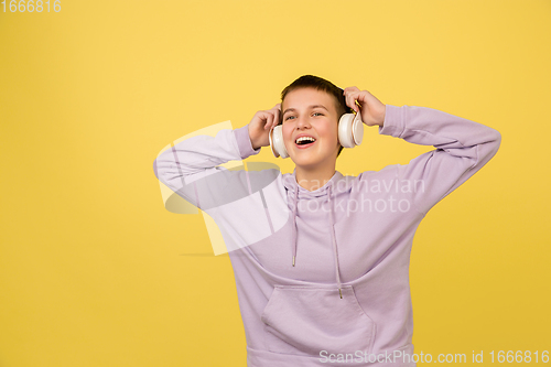 Image of Caucasian girl\'s portrait isolated on yellow studio background with copyspace