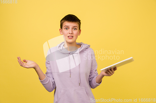 Image of Caucasian girl\'s portrait isolated on yellow studio background with copyspace