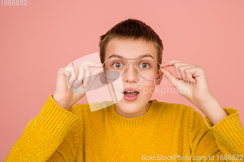 Image of Caucasian girl\'s portrait isolated on coral pink studio background with copyspace