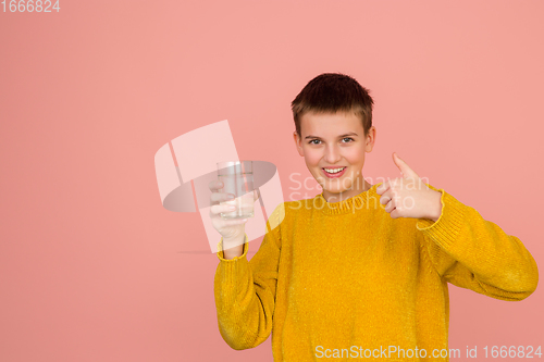 Image of Caucasian girl\'s portrait isolated on coral pink studio background with copyspace