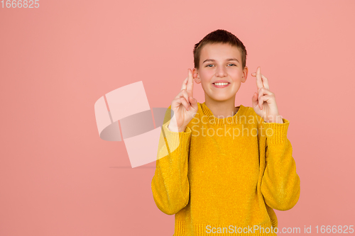 Image of Caucasian girl\'s portrait isolated on coral pink studio background with copyspace