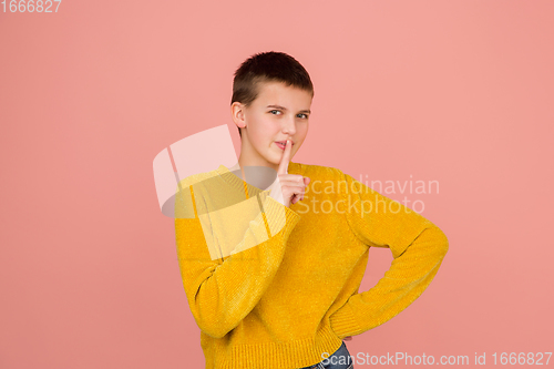 Image of Caucasian girl\'s portrait isolated on coral pink studio background with copyspace