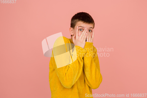 Image of Caucasian girl\'s portrait isolated on coral pink studio background with copyspace