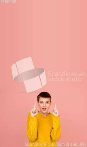 Image of Caucasian girl\'s portrait isolated on coral pink studio background with copyspace
