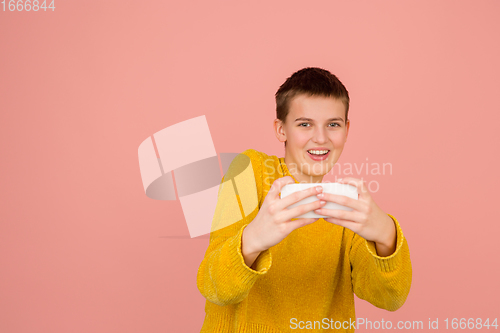 Image of Caucasian girl\'s portrait isolated on coral pink studio background with copyspace