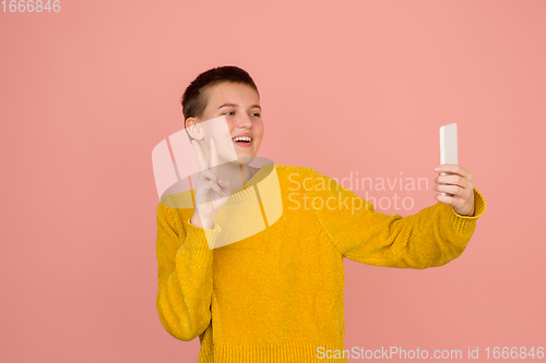 Image of Caucasian girl\'s portrait isolated on coral pink studio background with copyspace