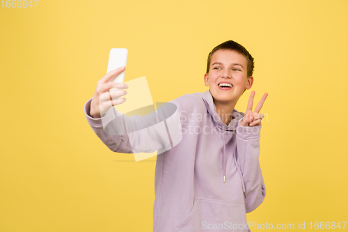 Image of Caucasian girl\'s portrait isolated on yellow studio background with copyspace